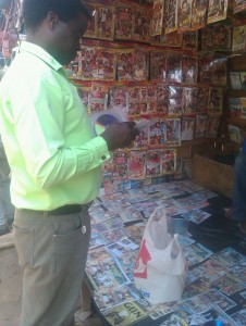 Police Criminal Investigations Department officer inspecting pirated CD-DVD at a market in Lilongwe Malawi - Credit COSOMA
