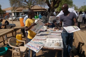 A man buys newspapers from a stand in the city of Juba.